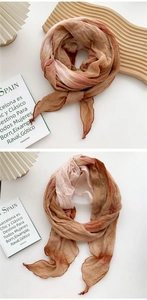 Detail of soft pink and rust red gradient tie-dye scarf with crinkle pleat texture