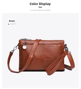Detail of brown crocodile pattern envelope bag with chain zipper and leather straps