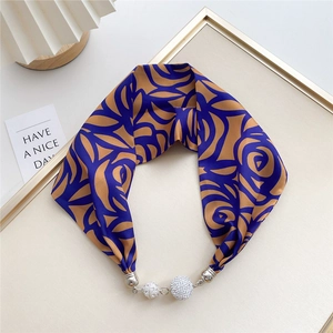 Detail of silk scarf necklace featuring blue abstract floral patterns and rhinestone charms