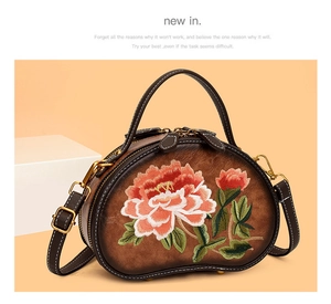 Detail shot of vintage brown leather bag with colorful floral peony embroidery and stitching