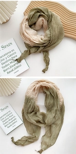 Detail of tie-dye cotton linen scarf showing beige and olive green pleated texture