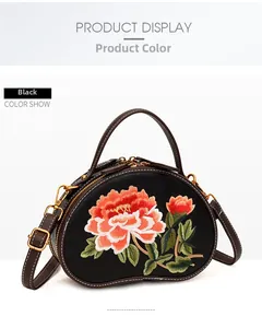 Close-up of black crossbody bag with floral embroidery and brown leather handle details