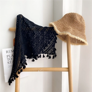 Châle en dentelle crochetée noire à franges avec chapeau de paille sur échelle bois