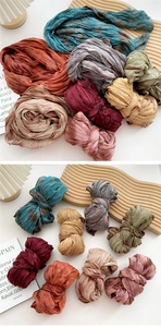 Detailed view of pleated cotton linen scarves with tie-dye textures and vibrant colors