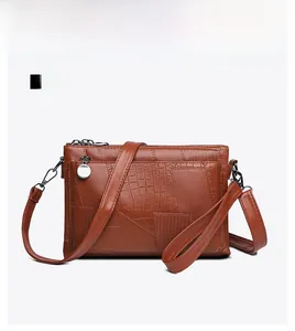 Detail of brown crocodile pattern PU leather crossbody bag with dual metal zippers