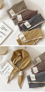 Detail of cotton linen gingham neckerchief with woven labels and textured fabric