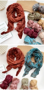 Detail of colorful pleated cotton linen scarves with hand-dyed patterns and fringe
