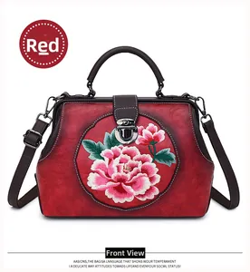 Close-up of red leather handbag with exquisite peony embroidery and retro clasp closure