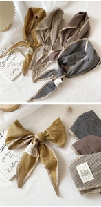 Detail of gingham cotton linen bow hairbands in yellow, brown, and navy blue options