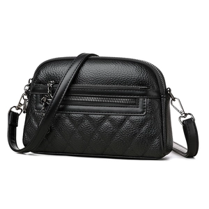 Minimalist black crossbody bag featuring lychee grain leather and quilted diamond texture
