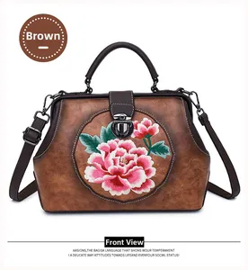 Close-up of vintage brown leather handbag with intricate peony flower embroidery and metal clasp