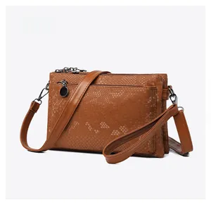 Mikroseitenansicht der braunen Schlangenleder-Handtasche mit Mehrschicht-Reißverschlüssen