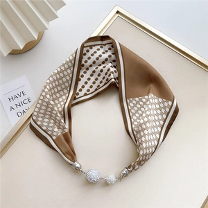 Detailed shot of brown and white polka dot silk scarf necklace with crystal magnetic buckle