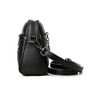 Minimalist black pebbled leather crossbody bag with dual zipper compartments and silver hardware