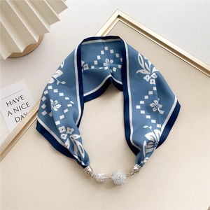 Detail of silk floral scarf necklace featuring blue pattern and rhinestone magnet clasp