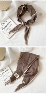 Detail showing checkered cotton linen scarf with beige piping and product info label
