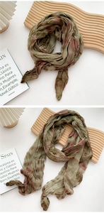 Close-up of pleated tie-dye cotton linen scarf in vintage green and rust red tones