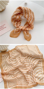 Detail of orange checkered cotton-linen scarf showing hemmed edges and light texture