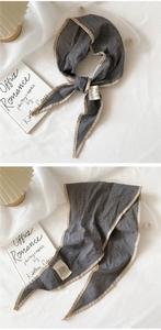 Macro detail of black and white checkered cotton linen scarf with beige hem and label