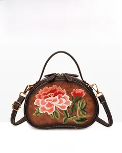Detailed front view of brown leather handbag with intricate peony flower embroidery