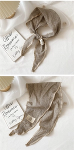 Detail of checkered cotton linen scarf showing fringed edges and minimalist product label