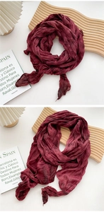 Close-up of pleated deep wine red cotton linen scarf with frayed edges and silk texture