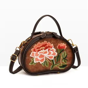 Detail view of vintage brown bag with exquisite peony flower embroidery and double zippers