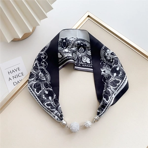 Macro shot of black and white lace floral silk scarf with magnetic rhinestone balls