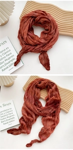 Detailed texture of red-brown crinkled cotton linen scarf with soft artistic drape