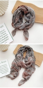 Detailed view of the pleated texture and grey-brown gradient on this cotton linen scarf
