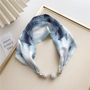 Detail of blue ink-wash silk scarf with a silver magnetic clasp and sparkling rhinestones