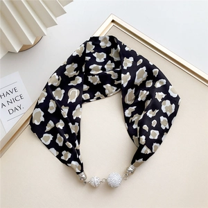 Detail view of leopard print silk scarf with luxury rhinestone magnetic ball closure