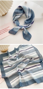 Detail of blue and white striped cotton-linen scarf showing sheer fabric texture and knot