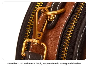 Macro detail of golden metal hooks on brown leather strap for small crossbody bag
