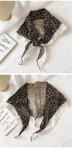 Detail of floral lace shawl featuring black fabric with white embroidery and ties