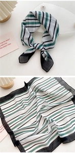 Detail of green and white striped cotton-linen scarf with elegant black edge finish