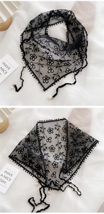 Détail d'un foulard triangle en dentelle noire avec broderies et perles