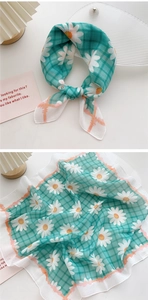 Detail of green and white checkered cotton linen scarf with small daisy flower prints