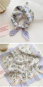 Detail of a lightweight floral square scarf with purple plaid border and daisy pattern