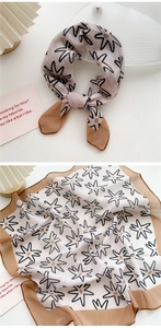 Detail view of cotton linen scarf featuring black floral prints and brown borders