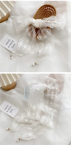 Detailed white lace ribbon with floral embroidery and elegant pearl pendant charms