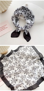Detail of a black and white cotton linen scarf with hand-painted star flower patterns