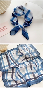 Detail of blue plaid cotton-linen scarf showing the delicate texture and hemmed edges