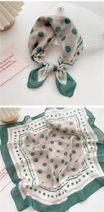 Detail view of dark green and beige polka dot silk scarf with striped borders