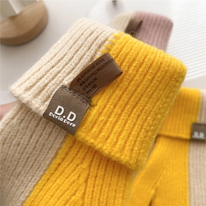 Winter knitted wool gloves in yellow and beige with a leather brand patch and soft texture