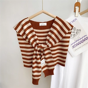 Vue détaillée du châle rayé en tricot avec nœud frontal et étiquette de marque