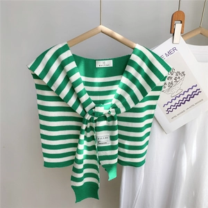 Détail du châle en tricot à rayures vertes et blanches avec étiquette et maille fine