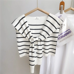 Détail du châle en tricot à rayures avec nœud frontal et étiquette de marque
