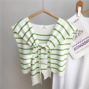 Détail d'un châle en tricot rayé avec motifs vert et blanc et design à nouer devant