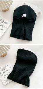 Detail of black knitted balaclava hood showing thick ribbed texture and white logo label
